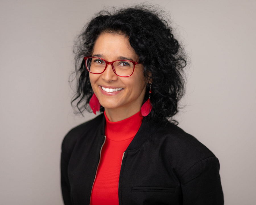 Freundlicher Headshot mit rotem Pullover und Brille