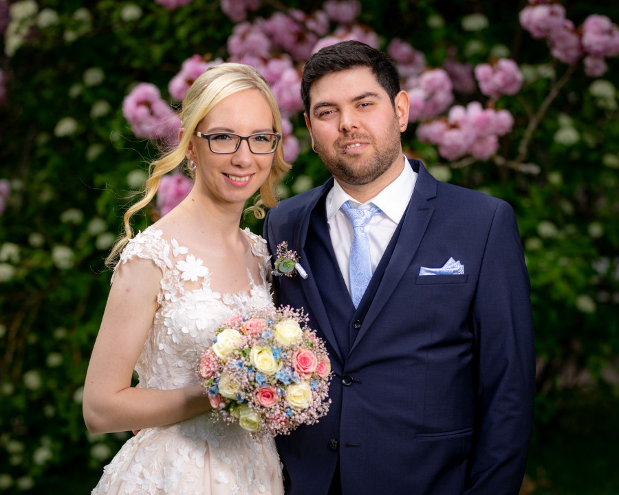 Brautpaar Kim und Timo unter bl&uuml;henden B&auml;umen
