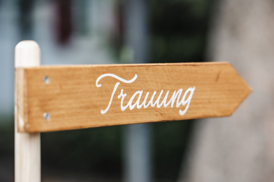 Holzschild mit der Aufschrift Trauung als Wegweiser zur Zeremonie
